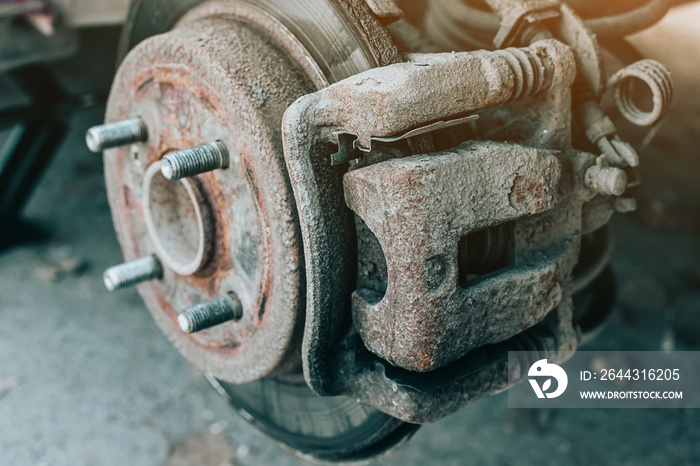 A rusty and old brake disc is serviced or replaced when the car is inspected by a mechanic. Safety and wear of the brake system