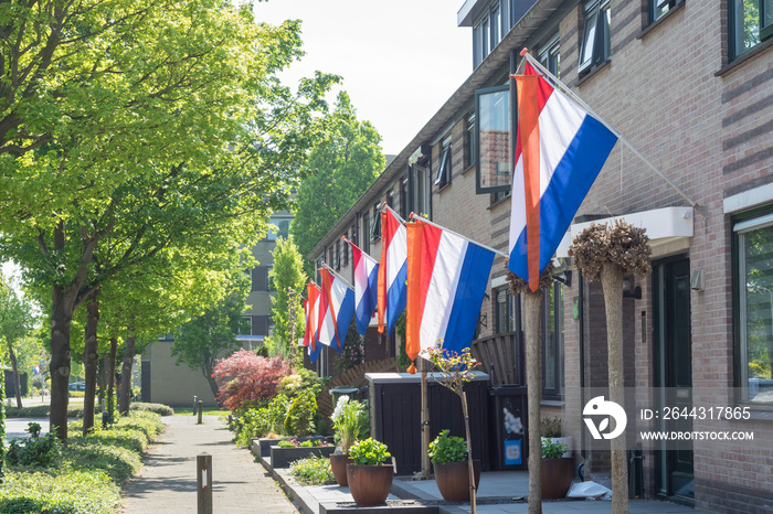 Street with dutch flags hanging outside on  Kingsday , a national holiday in The Netherlands