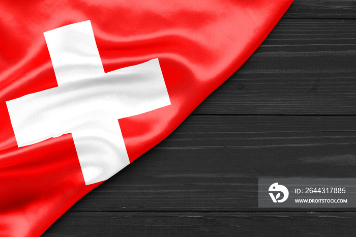 Flag of Switzerland and place for text on a dark wooden background