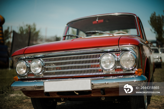 Color detail on the headlight of a vintage red car