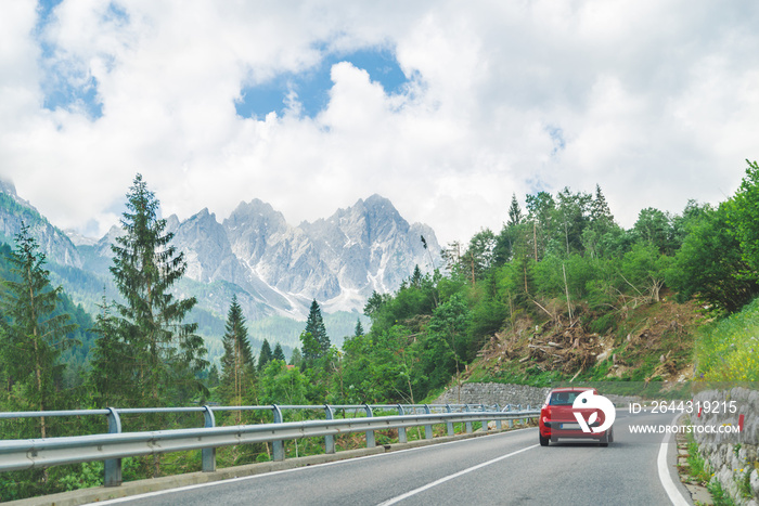 small red car on the road through mountains road trip