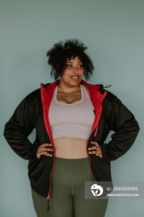 portrait of a plus size afro indigenous person looking away wearing athletic gear