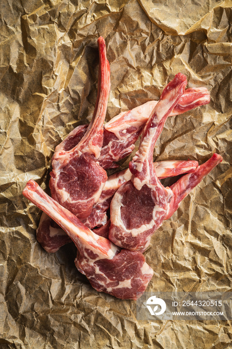 Slices raw lamb chops on baking paper.