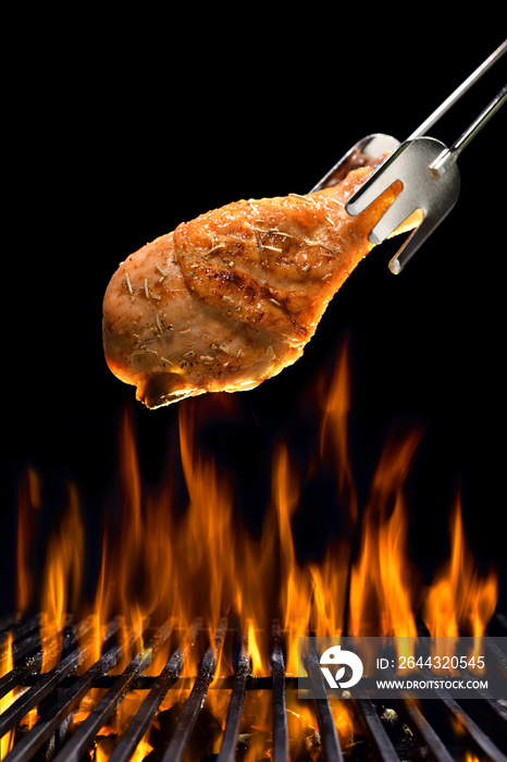 Grilled chicken leg on the flaming grill