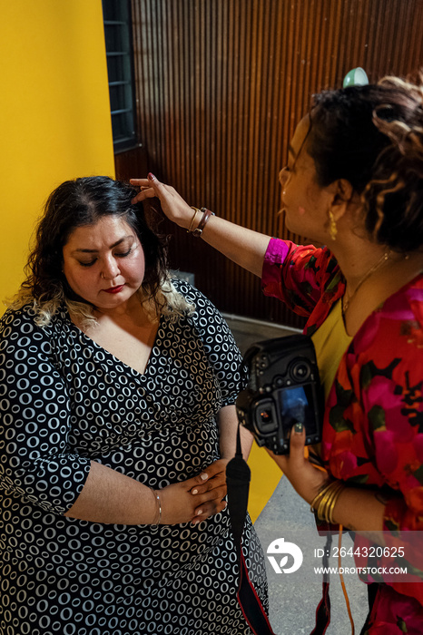 Plus sized female getting her headshots taken by a south asian female photographer