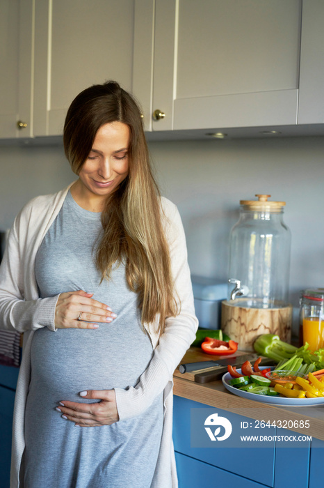 Smiling pregnat woman in the kitchen