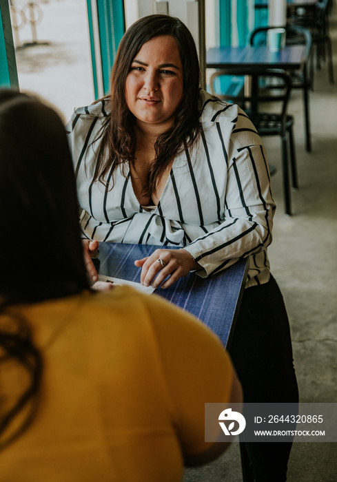 2 plus size women sit in cafe