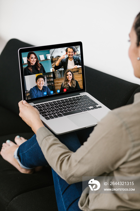 Back view of business latin woman talking to her mexican colleagues in video conference business team using laptop for a online meeting in video call working from home in Latin America