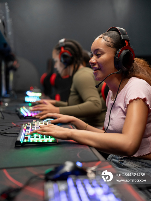 Female friends playing video games in gaming club