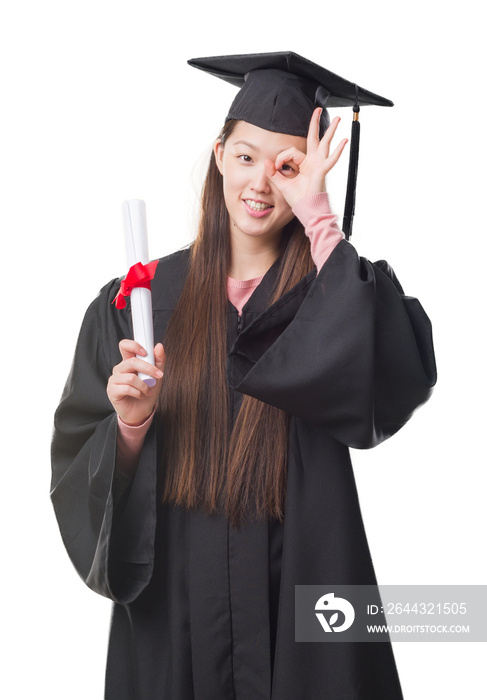 Young Chinese woman wearing graduate uniform holding paper degree with happy face smiling doing ok sign with hand on eye looking through fingers