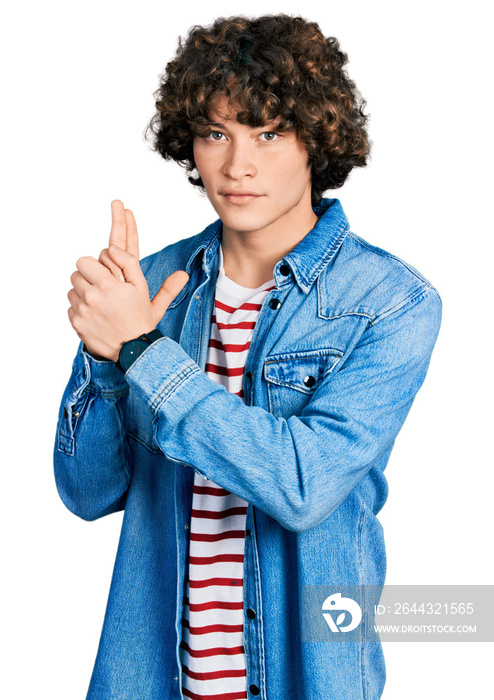 Caucasian teenager wearing casual clothes holding symbolic gun with hand gesture, playing killing shooting weapons, angry face