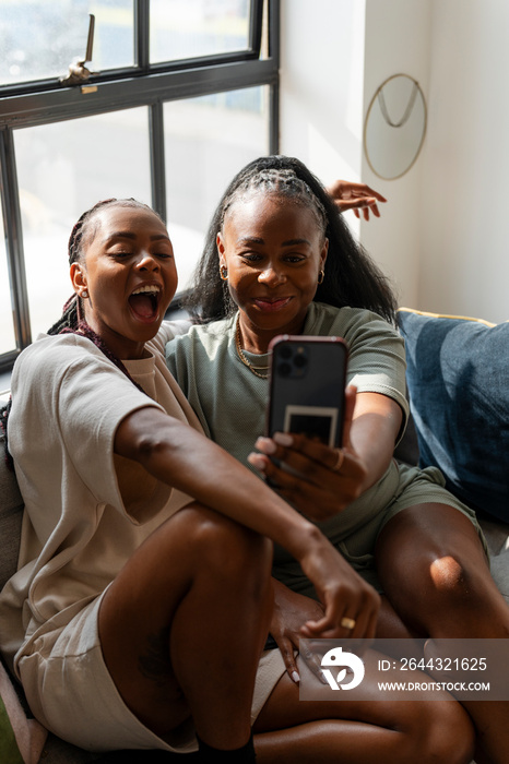 Lesbian couple taking selfie at home