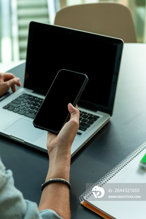 Close up shot of woman using smart phone and computer - stock photo