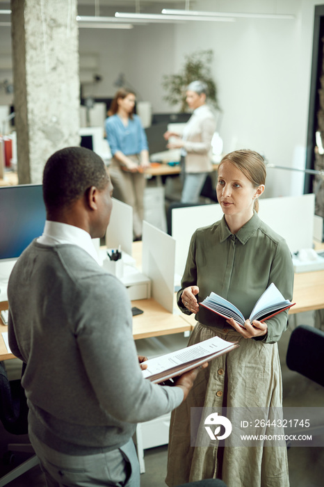 Business assistant communicating with her African American business mentor while working at corporate office.