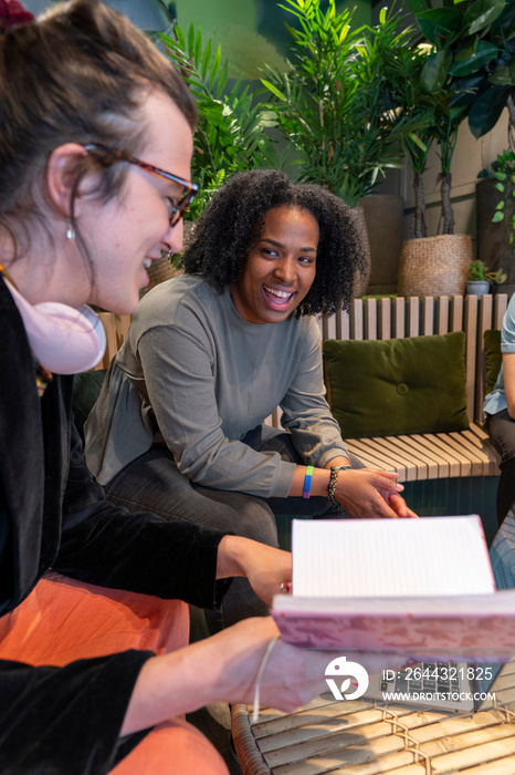 Colleagues laughing during meeting in office