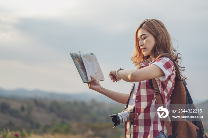 tourist woman looking a wrist watch and location map