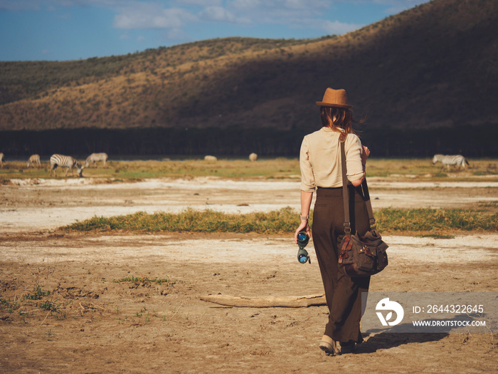 Beautiful woman with binoculars at savanna in Kenya