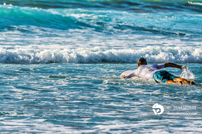 Surfer paddling to the line up