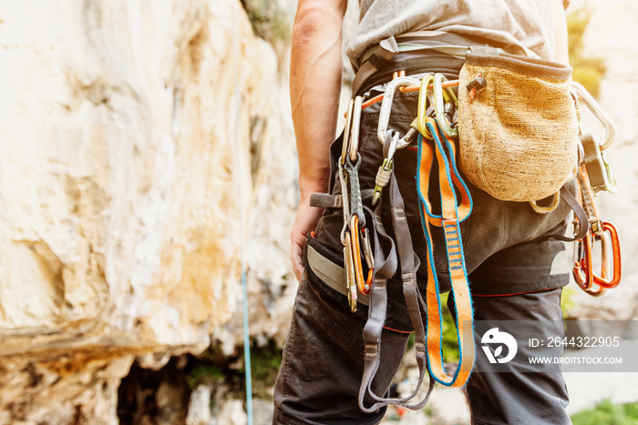 unrecognizable person with safety harness, climbing hooks and magnesium sack. climbing equipment. Mountain Sports.