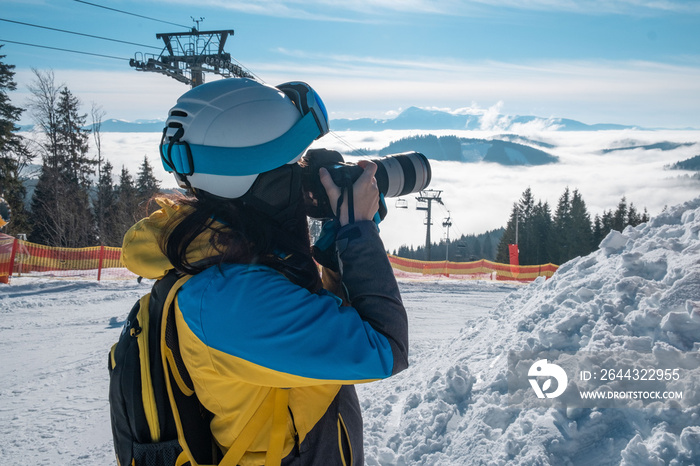 woman skier taking picture of mountains