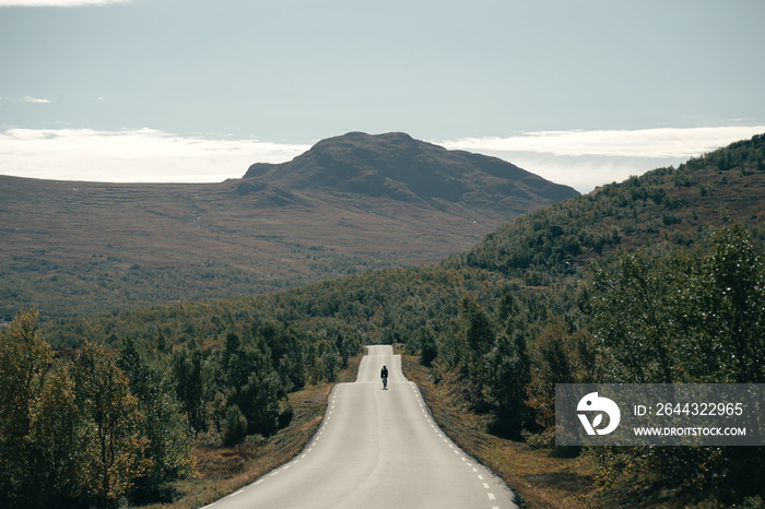 Road cyclist on empty mountain high altitude pass road. Cycling adventure in faraway destination. Road cycling in Norway. Carbon lightweight professional bicycle rider