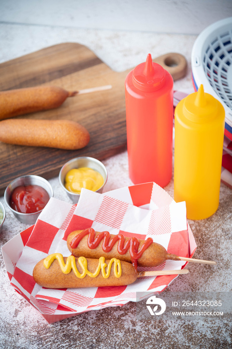 corn dog with ketchup and yellow mustard