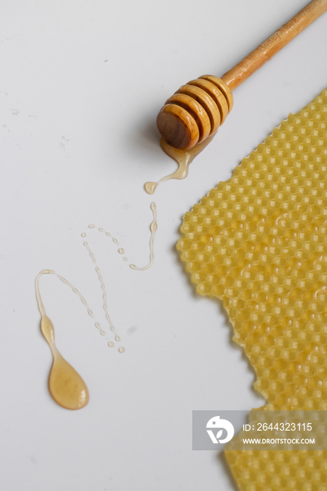 Spoon with raw honey and bee comb on white background, healthy nutrition concept