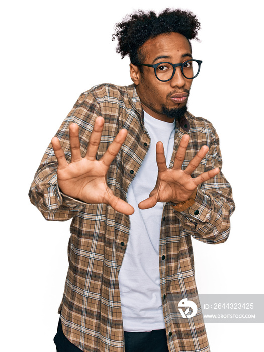 Young african american man with beard wearing casual clothes and glasses moving away hands palms showing refusal and denial with afraid and disgusting expression. stop and forbidden.