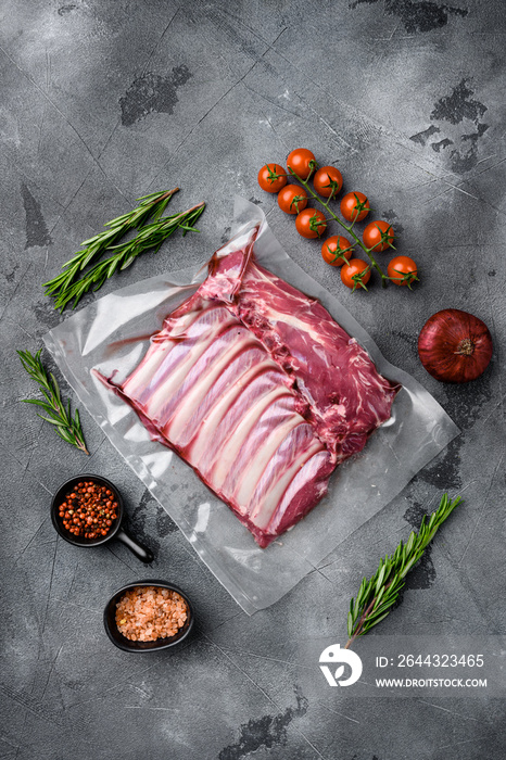 Lamb rib fresh meat Vacuum sealed, on gray stone table background, top view flat lay, with copy space for text