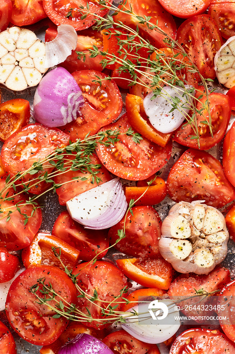 Raw red tomato, sliced, purple onion, garlic and thyme, top view, close up