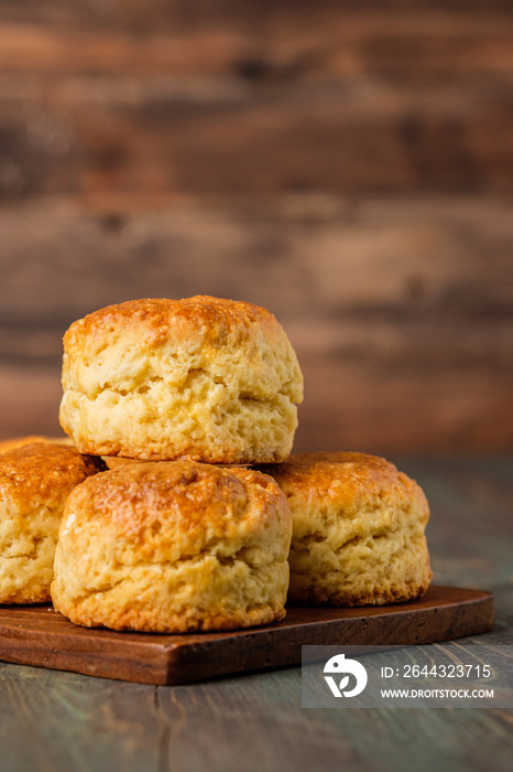 group of scones on wood plate with jam on table