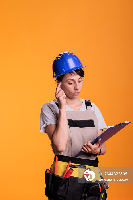 Woman contractor brainstorming ideas with clipboard files in studio, taking notes on papers and thinking about renovating solution. Industrial engineer using measurements to build site.