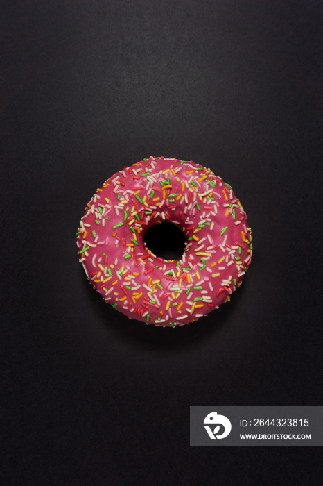 Creative food diet concept photo of donut bite on black background.