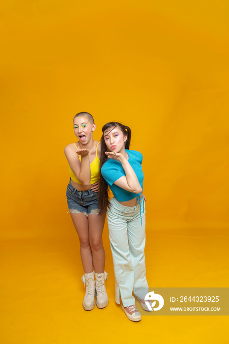 Studio portrait of stylish friends blowing a kiss