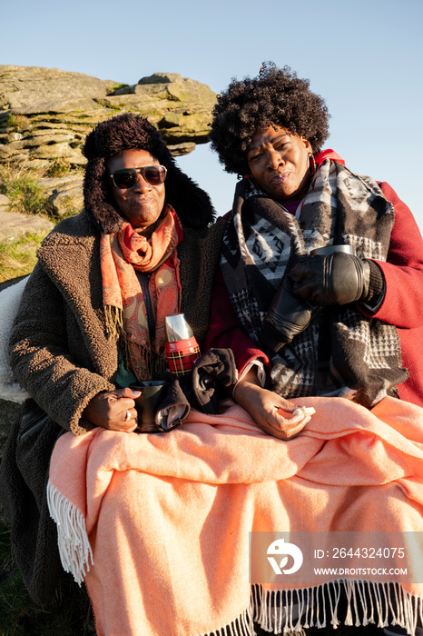 Portrait of two senior women enjoying hot drink in nature