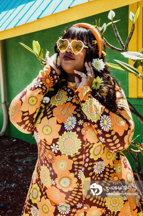 plus size African American woman wearing floral dress and heart sunglasses