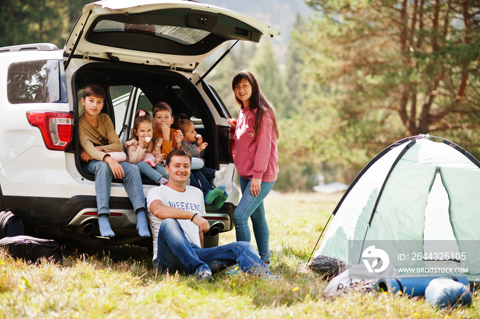 Large family of four kids. Children in trunk. Traveling by car in the mountains, atmosphere concept. American spirit.