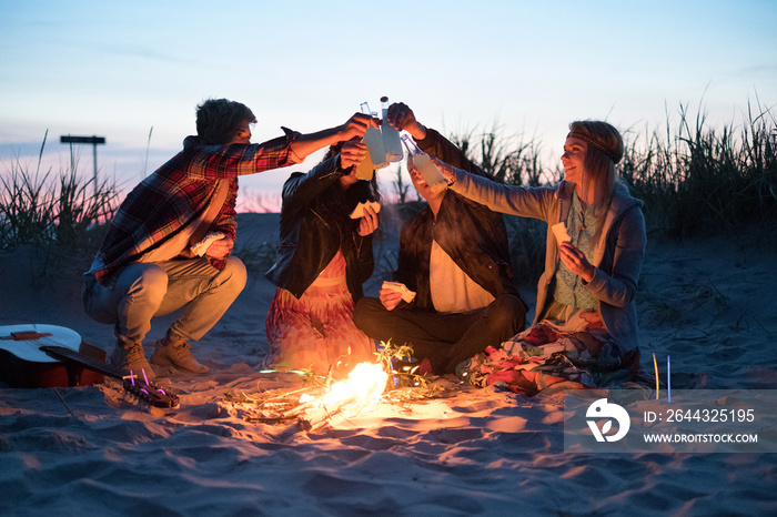 Hippie friends with guitar near bonfire