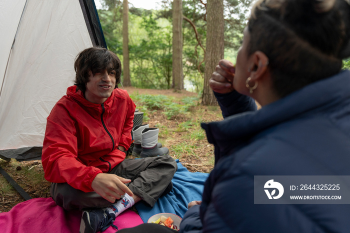 Mother and son eating snacks in tent