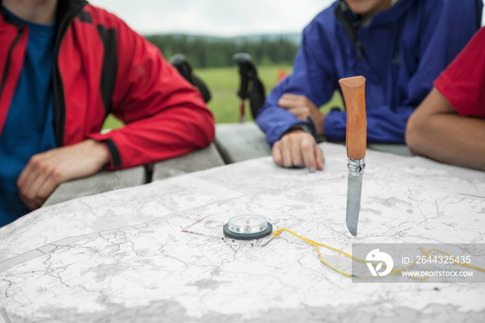 Hikers determining their destination with random knife throw