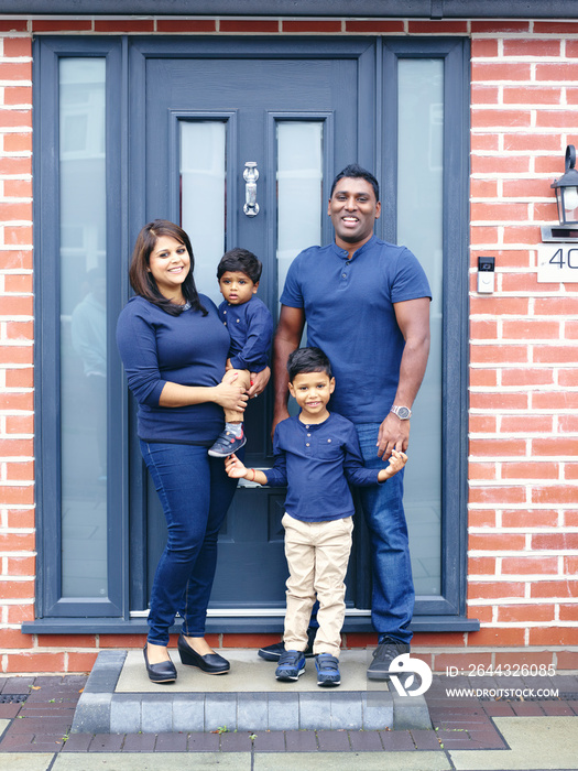 Portrait of family with sons standing on doorstep