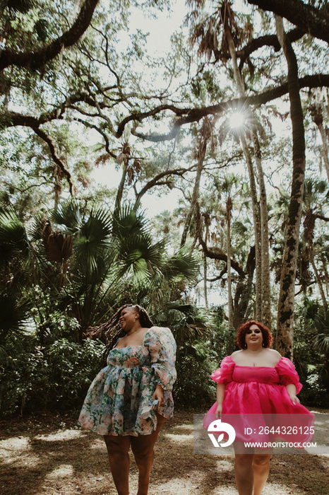 2 friends walk in the forest smiling