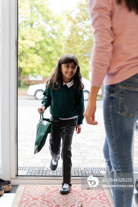 Schoolgirl entering house after returning from school