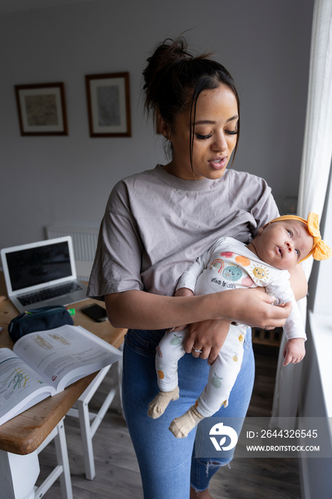 Mother carrying newborn baby girl at home