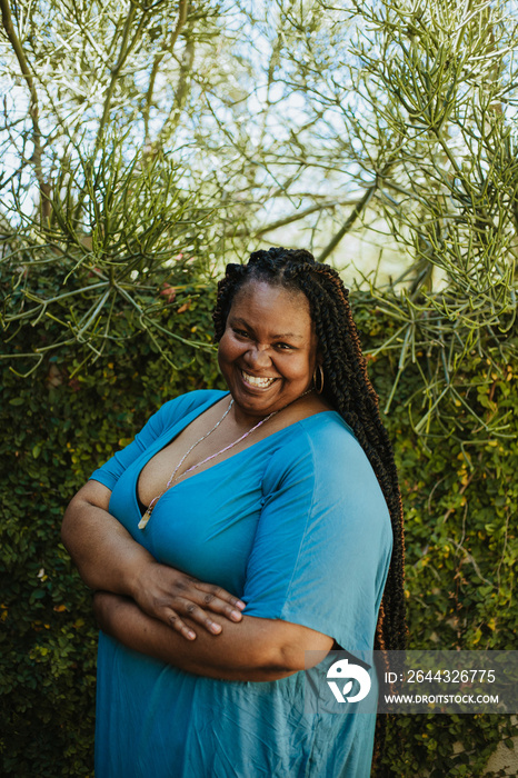 portrait of a plus size African American woman standing in front of plants