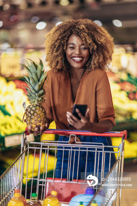 Cheerful African American Woman In Supermarket Choosing Fresh Fruits