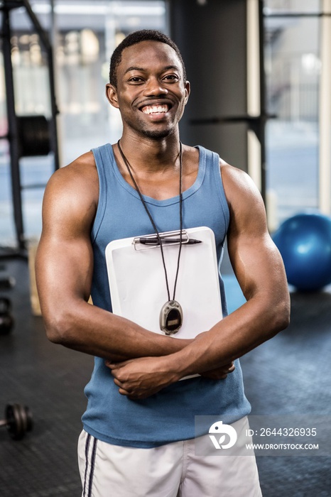 Confident trainer standing with clipboard