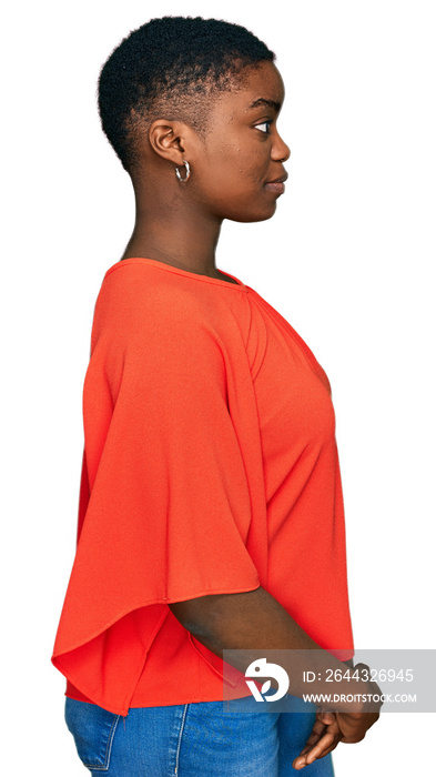 Young african american woman wearing casual clothes looking to side, relax profile pose with natural face with confident smile.