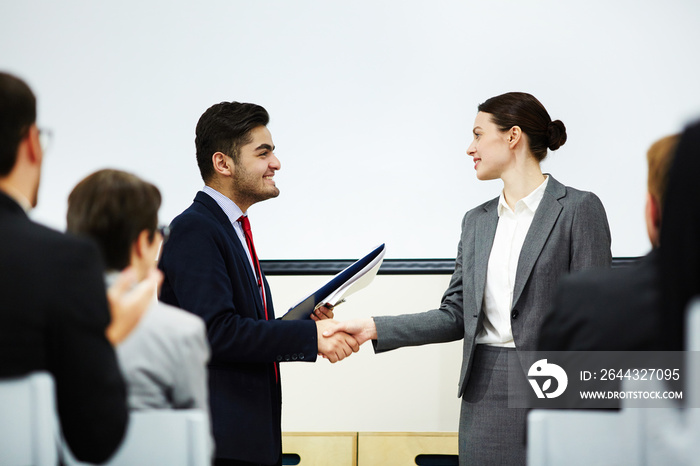 Coach congratulating one of business course attendants on graduation event