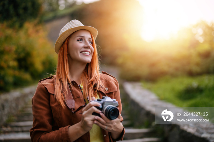 Beautiful female photographer using her camera outdoors